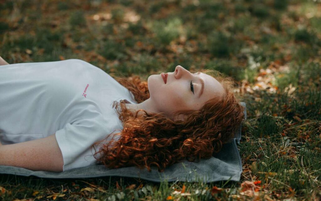 Devojka leži na travi i odmara